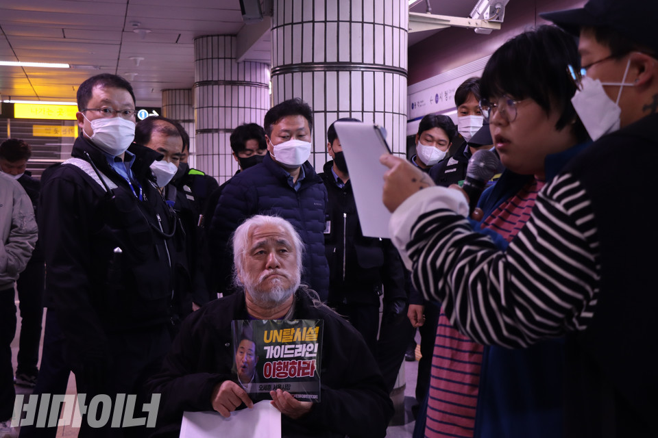 10일 오전 서울지하철 1호선 시청역에서 스티커를 든 박경석 전국장애인차별철폐연대 상임공동대표가 발언 중인 박경인 전국탈시설장애인연대에서 공동준비위원장을 바라보고 있다. 사진 복건우