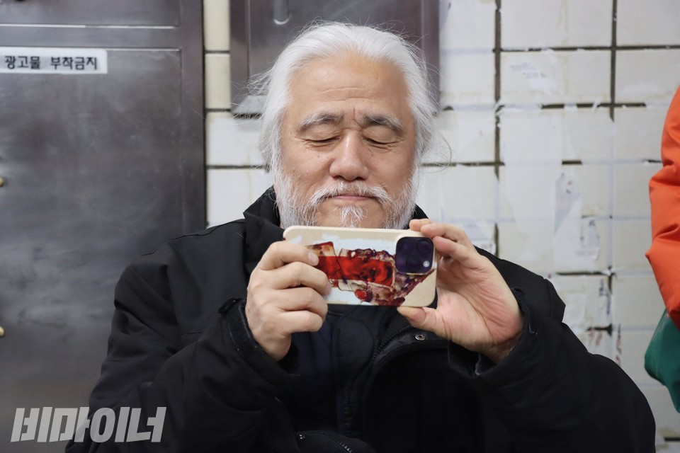 박경석 전장연 상임공동대표가 자신의 휴대전화로 선전전 현장을 촬영하고 있다. 사진 하민지