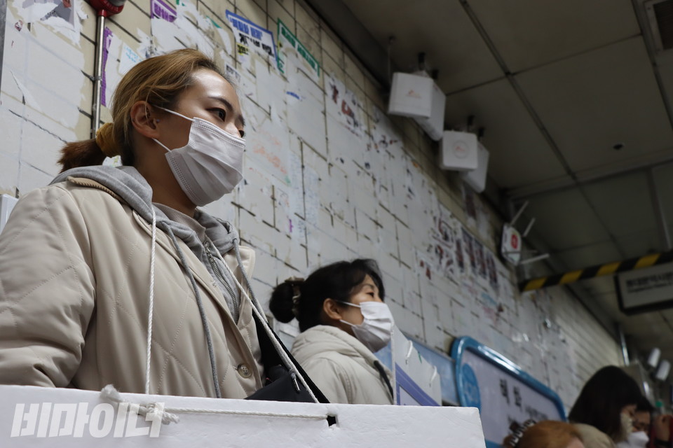 16일 오전 서울지하철 4호선 혜화역 승강장에서 김수경 씨(왼쪽)가 피켓을 목에 건 채 정면을 응시하고 있다. 사진 복건우
