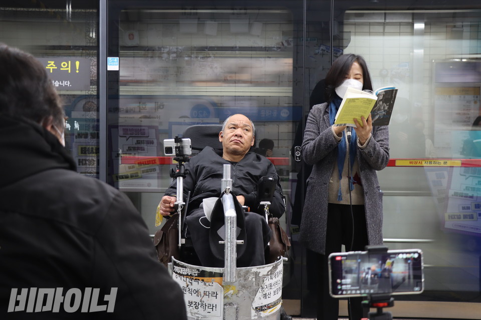 16일 오전 서울지하철 4호선 혜화역 승강장에서 강희석 나야장애인권교육센터 활동가(오른쪽)가 주디스 휴먼의 책 ‘나는, 휴먼’을 낭독하고 있다. 사진 복건우