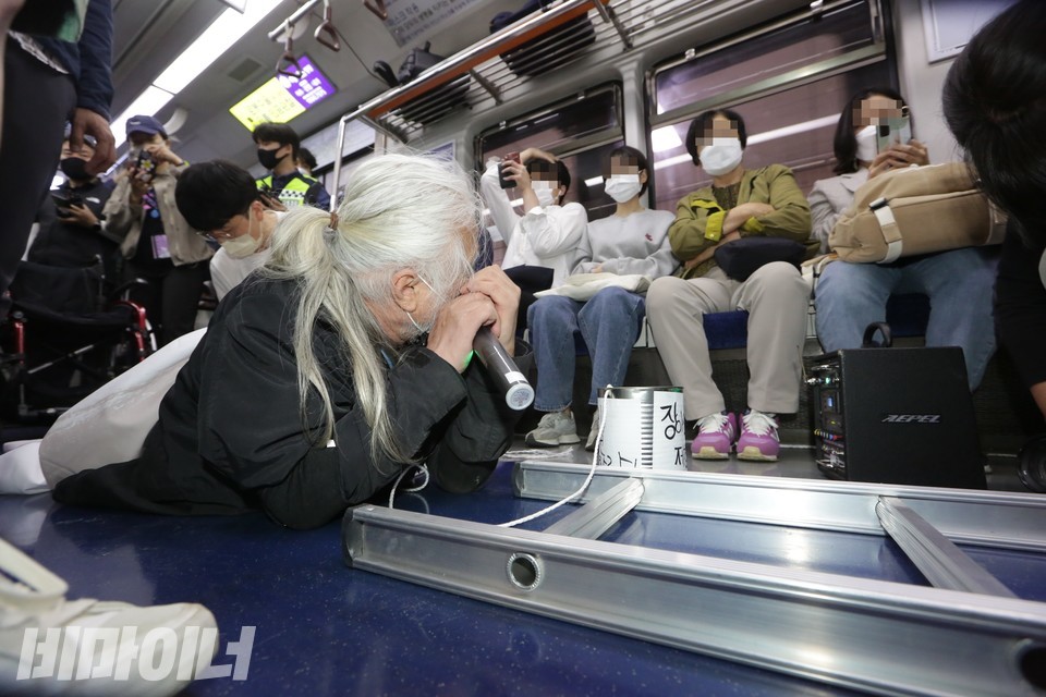 2022년 5월 11일 서울지하철 4호선 삼각지역에서 박경석 전국장애인차별철폐연대 상임공동대표가 지하철 바닥에 엎드린 채 승객들을 향해 말을 걸고 있다. 사진 비마이너 DB