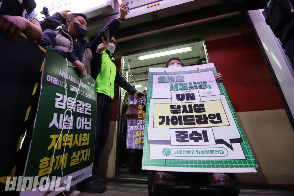 23일 오전 서울지하철 1호선 시청역 청량리 방면 승강장에서 이형숙 서울시장애인자립생활센터협의회 회장이 피켓을 든 채 열차에서 내리고 있다. 사진 복건우