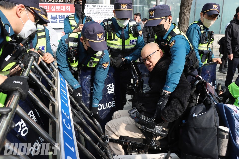 서기현 서울장애인차별철페연대 상임공동대표가 경찰에 의해 폭력적 진압을 당하고 있다. 사진 하민지