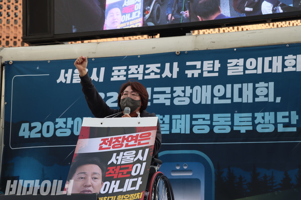 문애준 전남여성장애인연대 대표가 “투쟁”을 외치고 있다. 그는 목에 “전장연은 서울시 적군이 아니다”라고 적힌 피켓을 걸고 있다. 사진 하민지