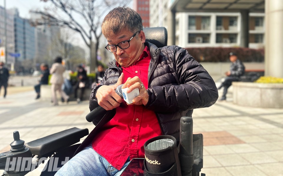 김주현 한국뇌병변장애인인권협회 정책국장이 의사소통보조기기(AAC)로 발언하고 있다. 김 국장 또한 전동휠체어 이용자다. 사진 하민지