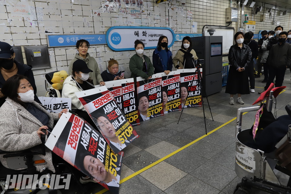 30일 오전 서울지하철 4호선 혜화역 선전전에 참여한 사람들이 승강장을 둘러싸고 ‘전장연은 서울시 적군이 아니다’라고 적힌 피켓을 들어 보이고 있다. 사진 복건우