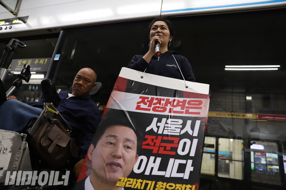 5일 오전 서울지하철 4호선 혜화역 선전전에 참여한 이예진 노들장애인야학 교사(오른쪽)가 피켓을 목에 걸고 발언하고 있다. 사진 복건우