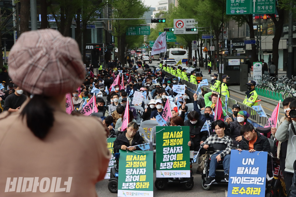 13일 오후 서울시청 동편 도로에서 열린 전국탈시설장애인연대 창립대회에 참여한 장애인들이 지민주 문화노동자의 축하공연을 보고 있다. 사진 복건우