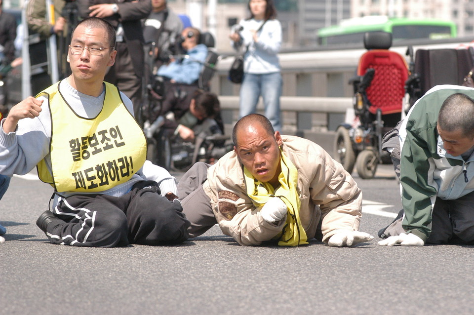 2006년 4월 27일, 중증장애인들이 활동보조제도화를 요구하며 한강대교를 6시간 동안 기었다. 가운데가 이규식. 사진 김유미