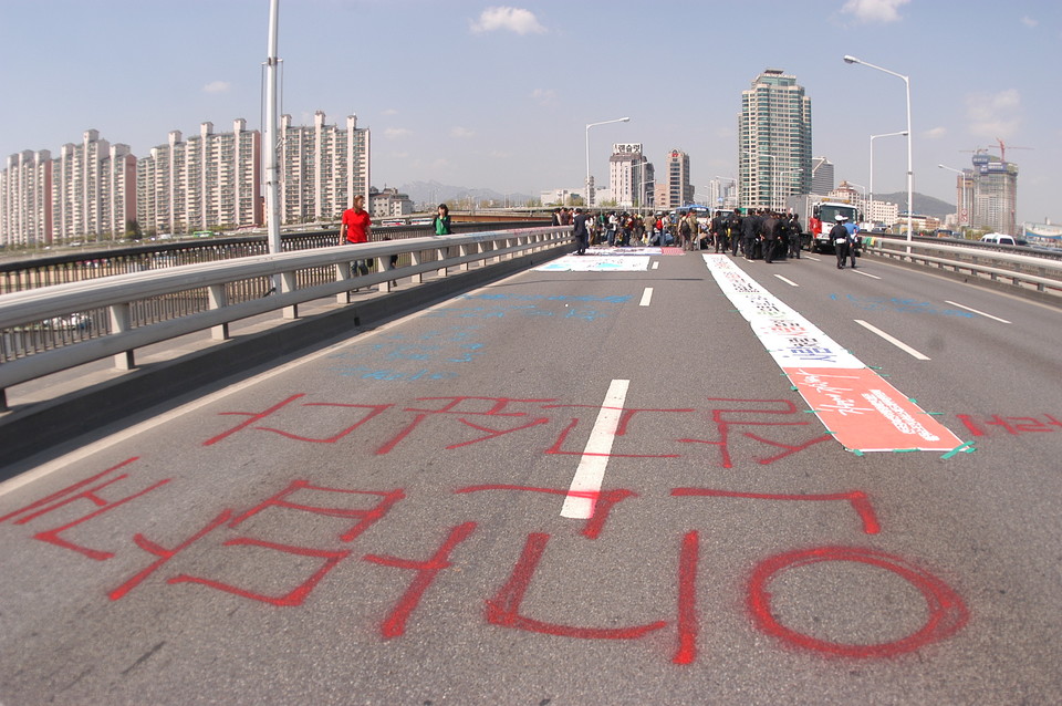 2006년 4월 27일, 중증장애인들이 활동보조제도화를 요구하며 한강대교를 6시간 동안 기었다. 아스팔트 바닥에 붉은색 스프레이로 “인간답게 살고 싶다”고 쓰여 있다. 사진 김유미