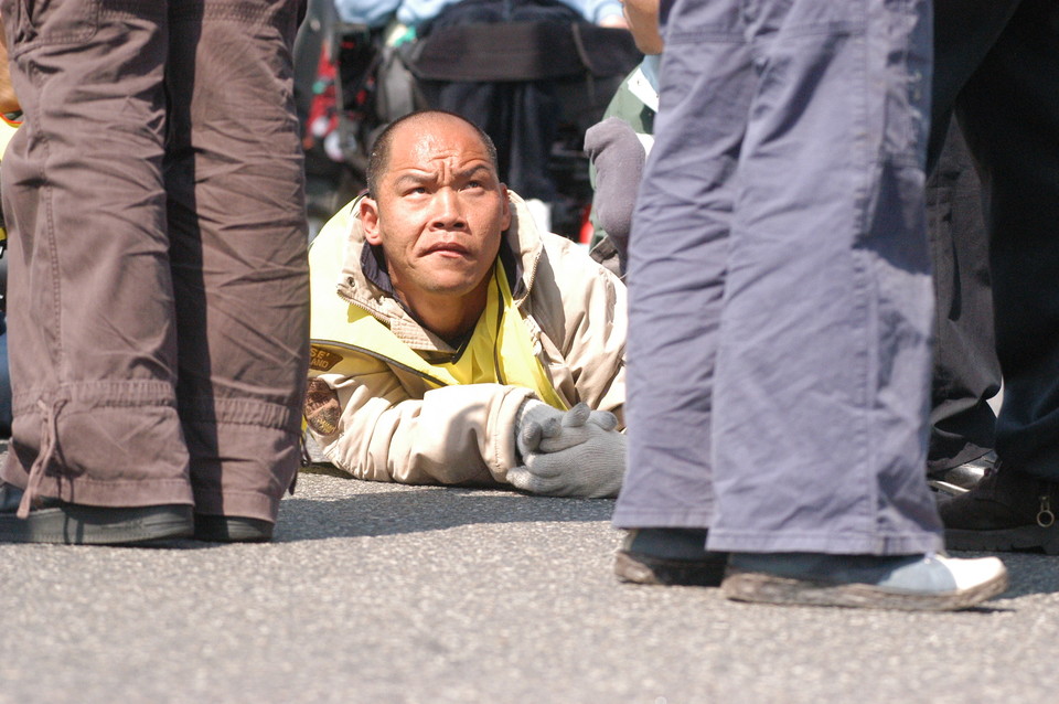 2006년 4월 27일, 중증장애인들이 활동보조제도화를 요구하며 한강대교를 6시간 동안 기었다. 이규식이 기어가다가 서 있는 사람을 올려다보고 있다. 사진 김유미