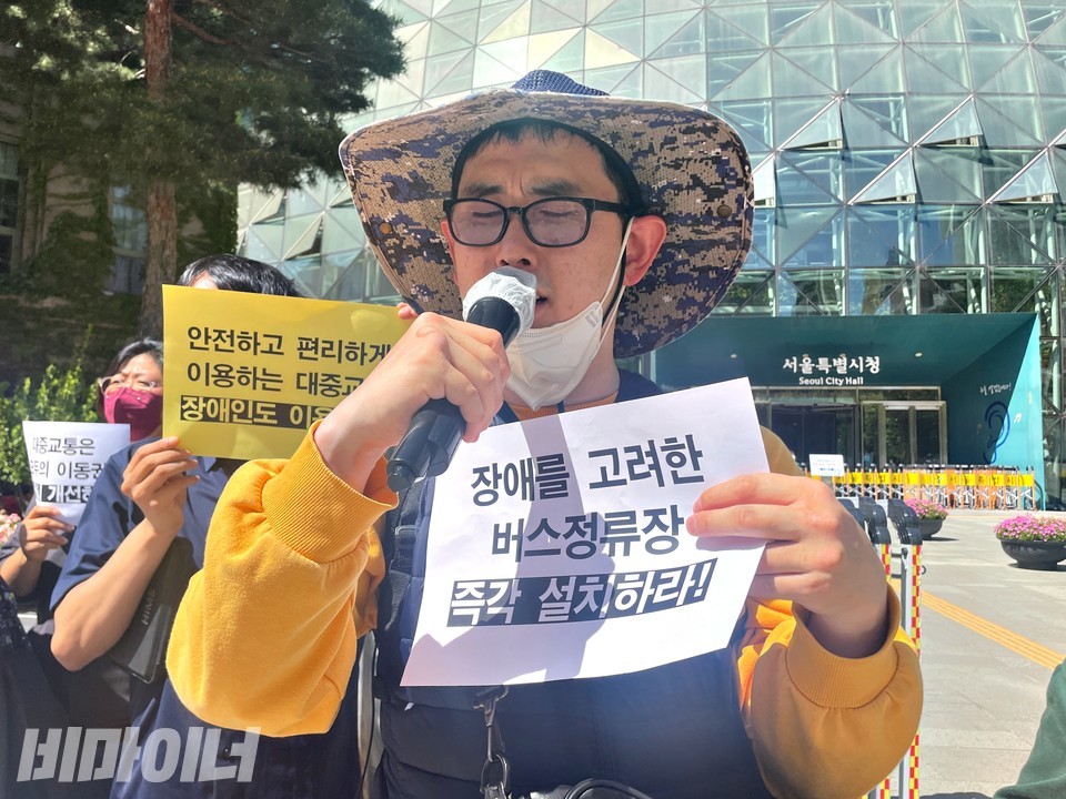 곽남희 노들장애인자립생활센터 활동가가 발언 중이다. 그는 “장애를 고려한 버스정류장 즉각 설치하라”라고 적힌 피켓을 들고 있다. 사진 하민지