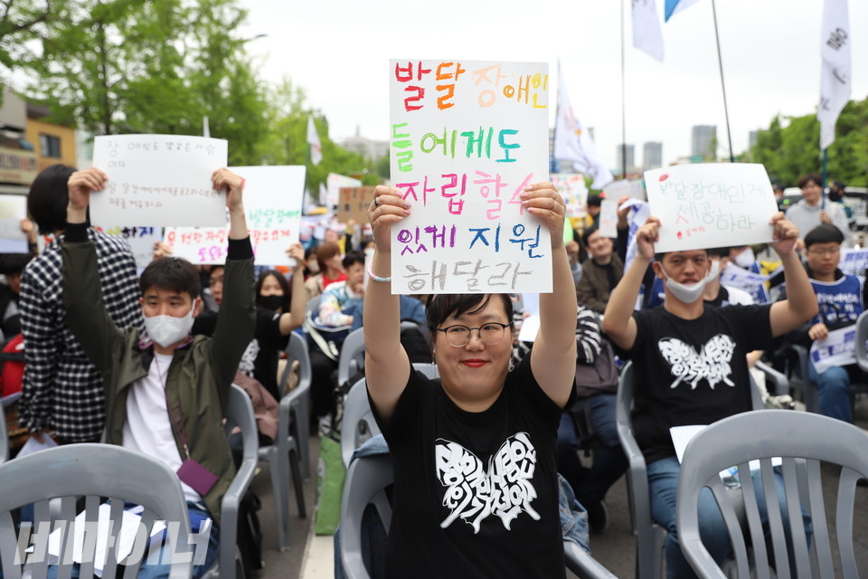 문윤경 한국피플퍼스트 대표가 “발달장애인들에게도 자립할 수 있게 지원해달라”고 적힌 피켓을 들고 있다. 사진 강혜민