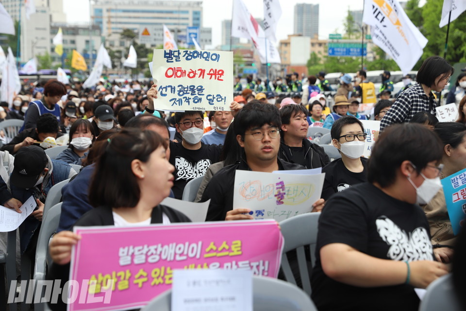 김정훈 활동가가 “발달장애인이 이해하기 쉬운 선거공보물을 제작해달라”고 적힌 피켓을 들고 있다. 사진 강혜민