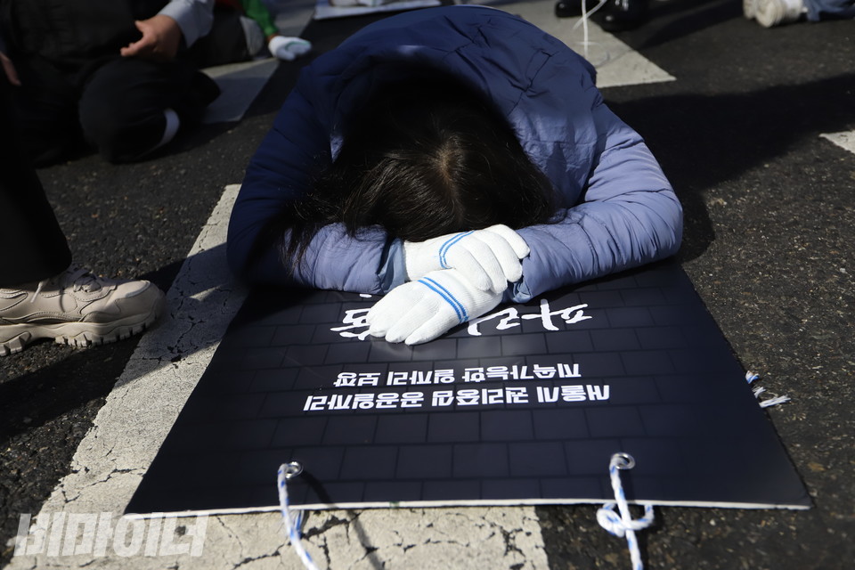 한 활동가가 오체투지 도중 힘들어 잠시 얼굴을 파묻고 쉬고 있다. 사진 강혜민