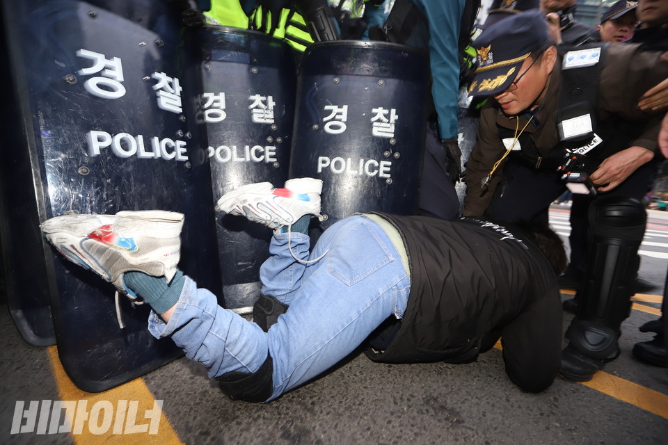 유진우 노들장애인자립생활센터 활동가가 행진 도중 길을 막아선 경찰에 항의하며 휠체어에서 내려와 기어가고 있다. 사진 강혜민
