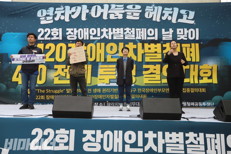 양동규 민주노총 부위원장, 이원호 빈곤사회연대 집행위원장, 김은정 참여연대 협동사무처장이 발언을 위해 무대에 올랐다. 그 옆에서 수어통역사가 수어로 통역하고 있다. 사진 강혜민