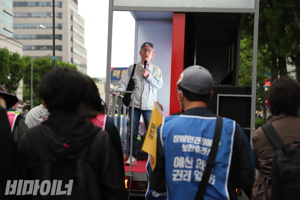 부모연대 활동가가 행진 차량에 올라서서 발달장애인 24시간 지원체계를 촉구하고 있다. 사진 강혜민