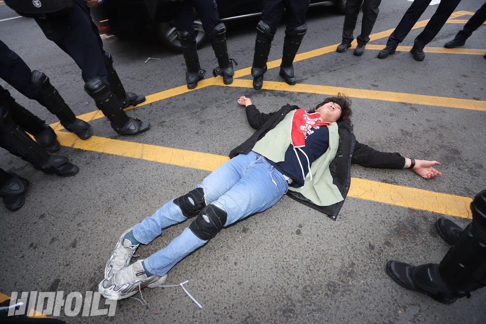 휠체어에서 내려와 바닥을 기어가며 경찰에게 항의하던 유진우 노들장애인자립생활센터 활동가가 바닥에 누워 잠시 숨을 고르고 있다. 사진 강혜민