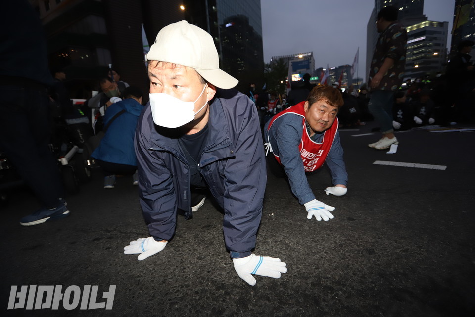 서울시청 앞 플라자호텔. 장애인 활동가들이 휠체어에서 내려와 바닥을 기어가고 있다. 사진 강혜민
