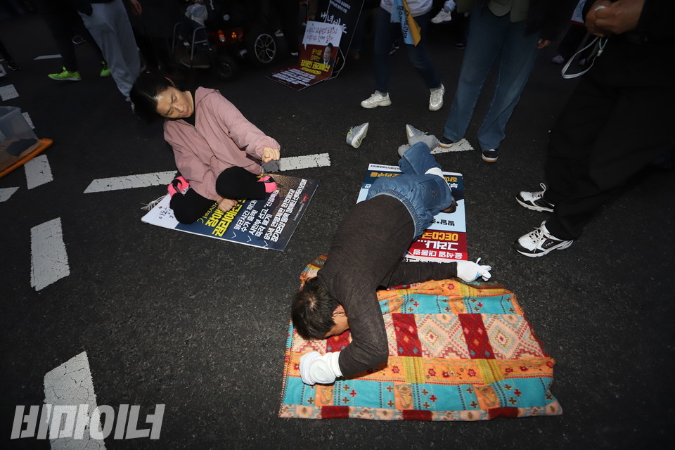 서울시청 앞 플라자호텔. 장애인 활동가들이 휠체어에서 내려와 바닥을 기어가고 있다. 사진 강혜민