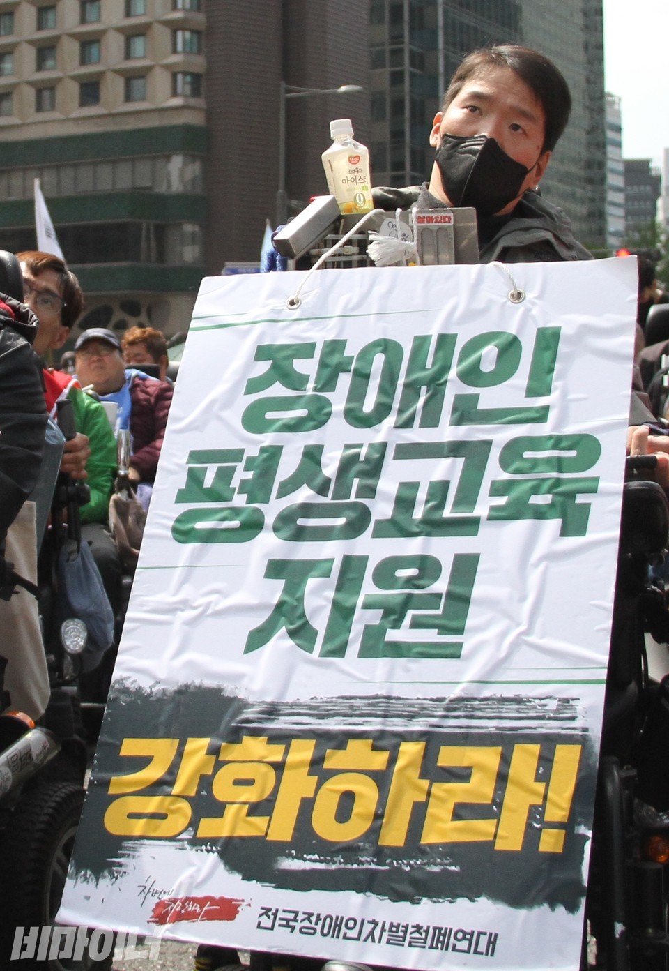 박지호 노들장애인야학 학생이 “장애인평생교육 지원 강화하라”라고 적힌 피켓을 목에 걸고 있다. 사진 하민지