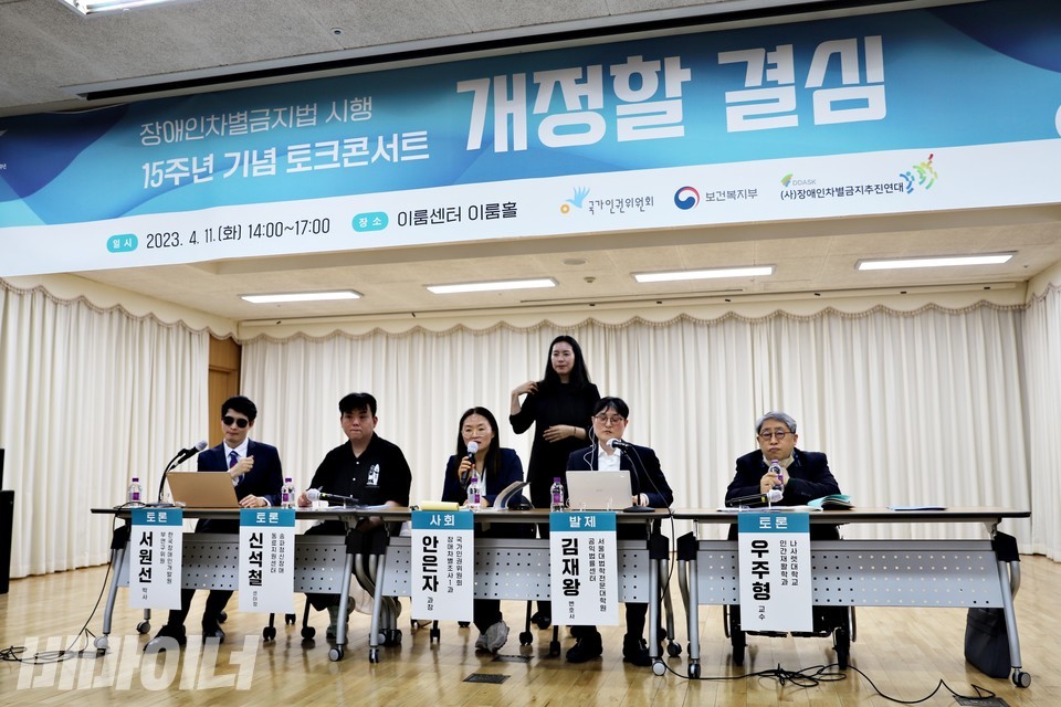 장애인차별금지법 시행 15주년 기념 토크콘서트 현장. 사회자, 수어통역사, 발제자, 토론자 등 6명이 무대에 있다. 사진 하민지