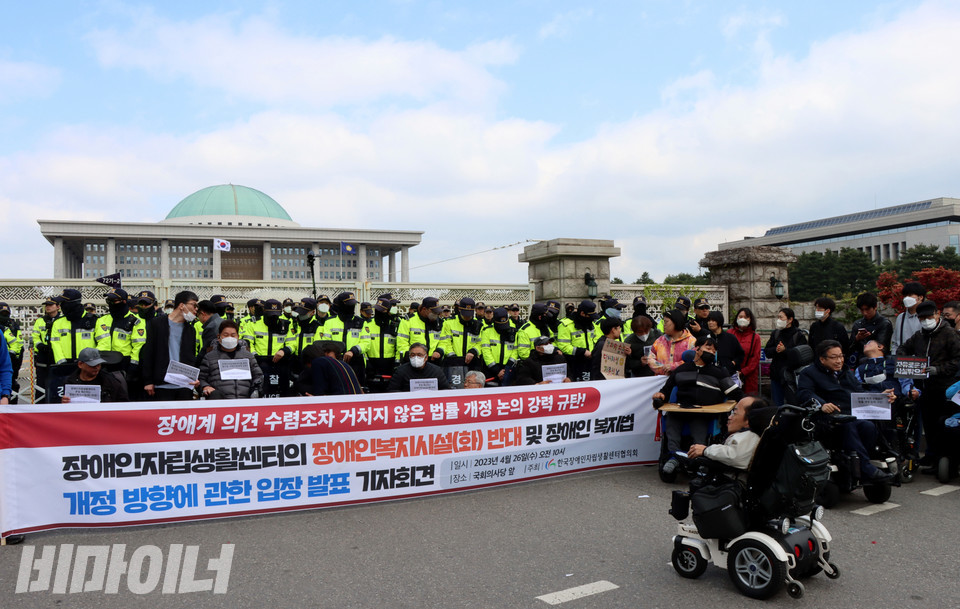 26일 오전 서울 여의도 국회의사당 앞에서 열린 ‘장애인자립생활센터 장애인복지시설(화) 반대 및 장애인복지법 개정안 법안소위 통과 규탄’ 기자회견 현장. 경찰들이 장애인 활동가들을 둘러싸고 있다. 사진 복건우