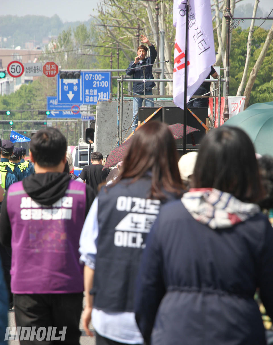 유정우 씨가 트럭 위에서 노래를 부르고 있다. 그 뒤로 행진하는 사람들이 뒤따르고 있다. 사진 강혜민 