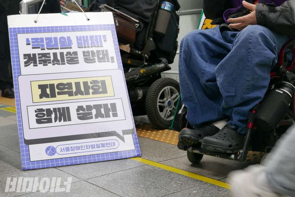 박경석 대표의 발 옆에 “격리와 배제, 거주시설 반대, 지역사회 함께 살자!”라고 적힌 피켓이 있다. 사진 양유진