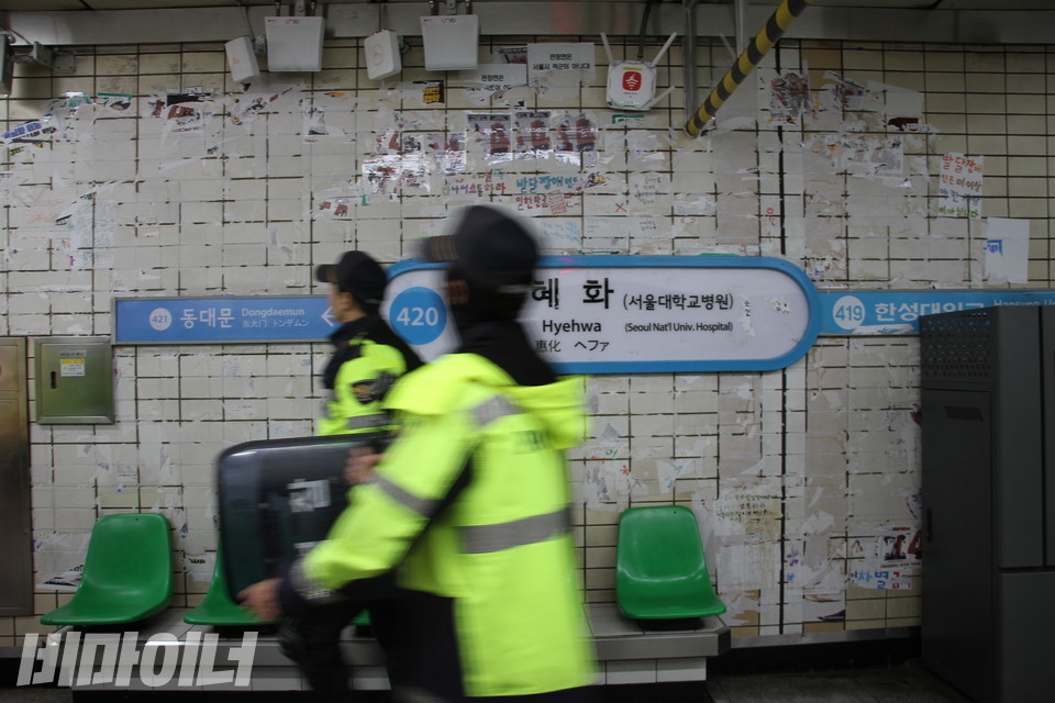서울교통공사 직원들에 의해 스티커는 곧바로 제거됐다. 다시 텅 비워진 벽면 앞을 방패를 든 경찰이 지나간다. 사진 강혜민