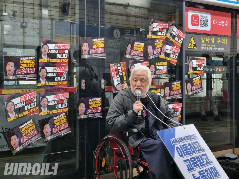 4일 오전 서울지하철 4호선 혜화역 승강장에서 박경석 전국장애인차별철폐연대 상임공동대표가 지하철 스크린도어에 선전전 스티커를 붙인 뒤 발언하고 있다. 사진 복건우