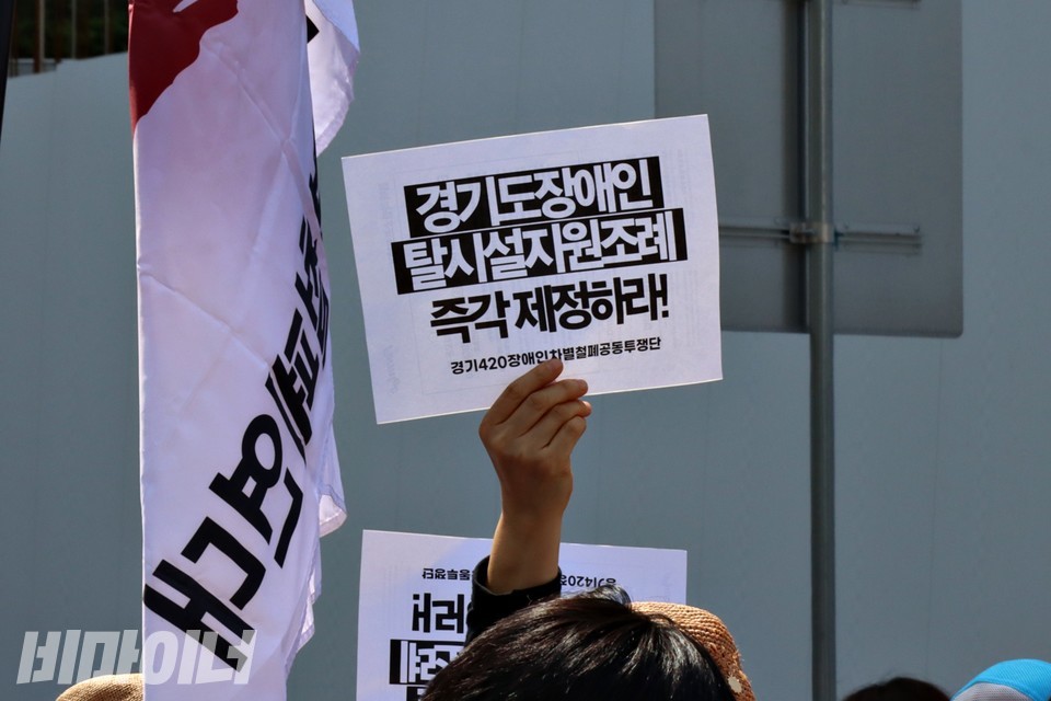 한 활동가가 “경기도 장애인탈시설지원조례 즉각 제정하라”라고 적힌 피켓을 높이 들어보이고 있다. 사진 하민지