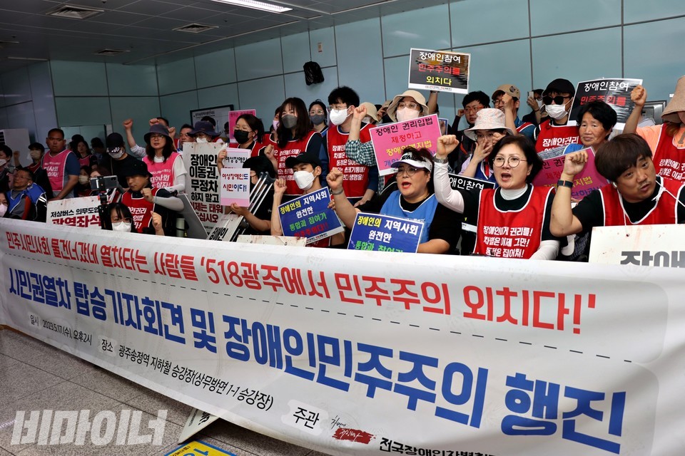 장애인운동단체 활동가 200여 명이 광주송정역에서 기자회견을 열고 있다. 현수막에는 “민주시민사회 물건너갔네 열차타는 사람들 518광주에서 민주주의 외치다! 시민권열차 탑승기자회견 및 장애인민주주의 행진”이라고 적혀 있다. 사진 하민지