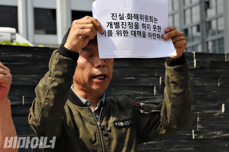 덕성원 피해생존자 안종환 씨가 “진화위는 개별진정을 하지 못한 이를 위한 대책을 마련하라”라는 피켓을 높이 들고 있다. 사진 하민지