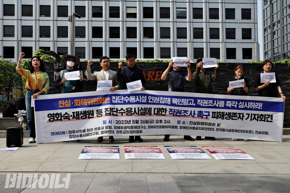 시설수용 피해생존자들과 장애인운동단체, 시민사회단체 활동가들이 진화위 앞에서 기자회견을 열고 있다. 현수막에는 “진화위는 집단수용시설 인권침해 묵인 말고 직권조사를 즉각 실시하라! 영화숙, 재생원 등 집단수용시설에 대한 직권조사 촉구 피해생존자 기자회견”이라 적혀 있다. 사진 하민지