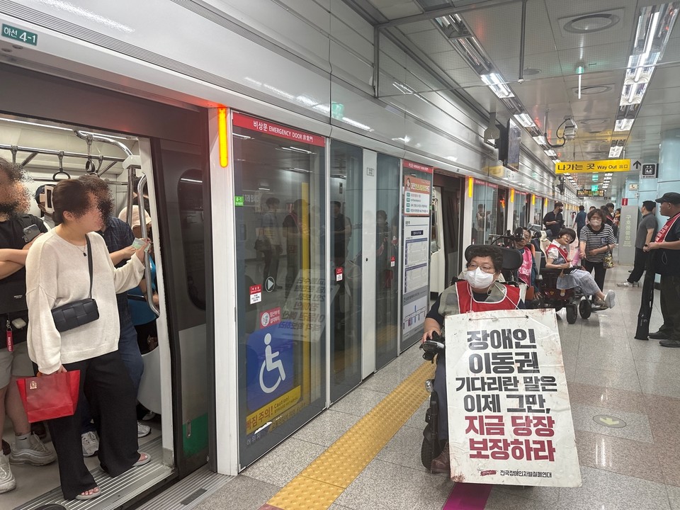 장애인들이 열차에서 하차하고 있고, 열차 내 대전 시민 여러 명이 이를 쳐다보고 있다. 사진 대전장차연