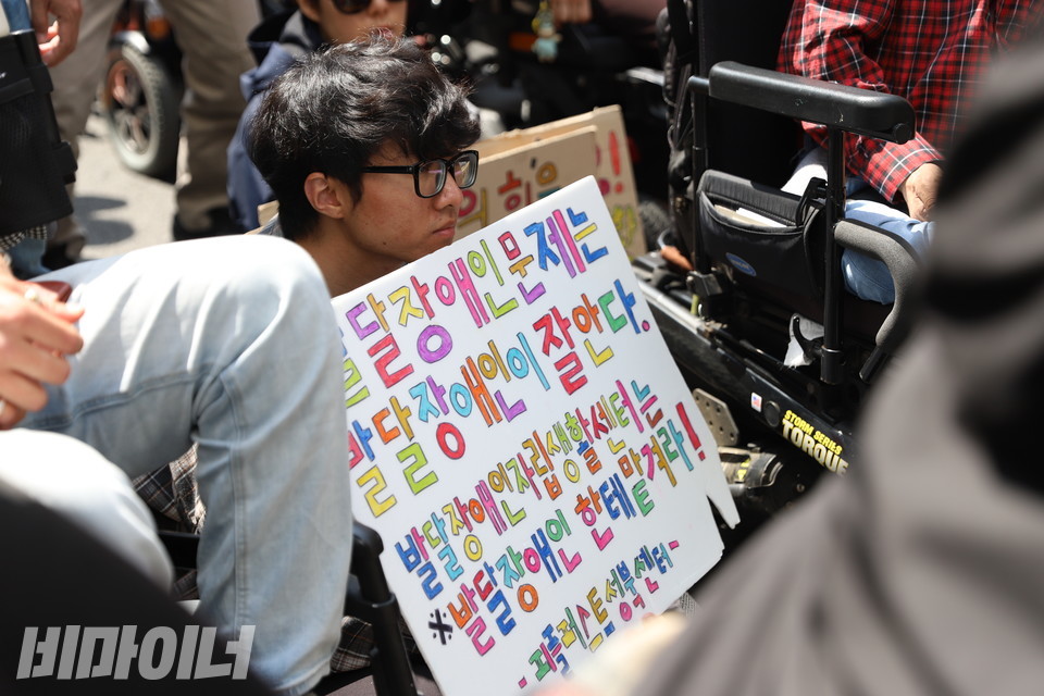 한 활동가가 5월 9일 더불어민주당 당사 앞에서 열린 기자회견에서 “발달장애인 문제는 발달장애인이 잘 안다. 발달장애인자립생활센터는 발달장애인한테 맡겨라. 피플퍼스트성북센터”라고 적힌 피켓을 들고 있다. 사진 강혜민