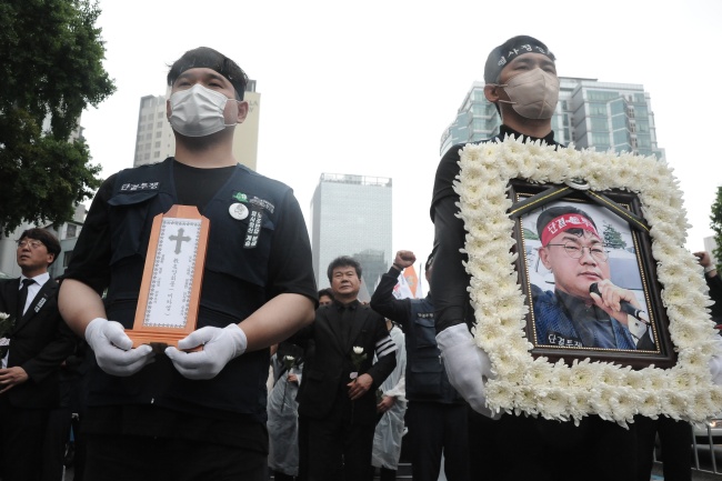 지난 21일 양회동 열사 노동시민사회장이 치러졌다. 경찰청 앞 노제 행렬. 건설노조 조합원이 양회동 열사의 영정을 들고 있다. 사진 참세상 