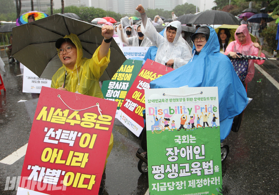 폭우 속에서 활동가들이 장애인권리입법을 요구하며 외치고 있다. 사진 강혜민