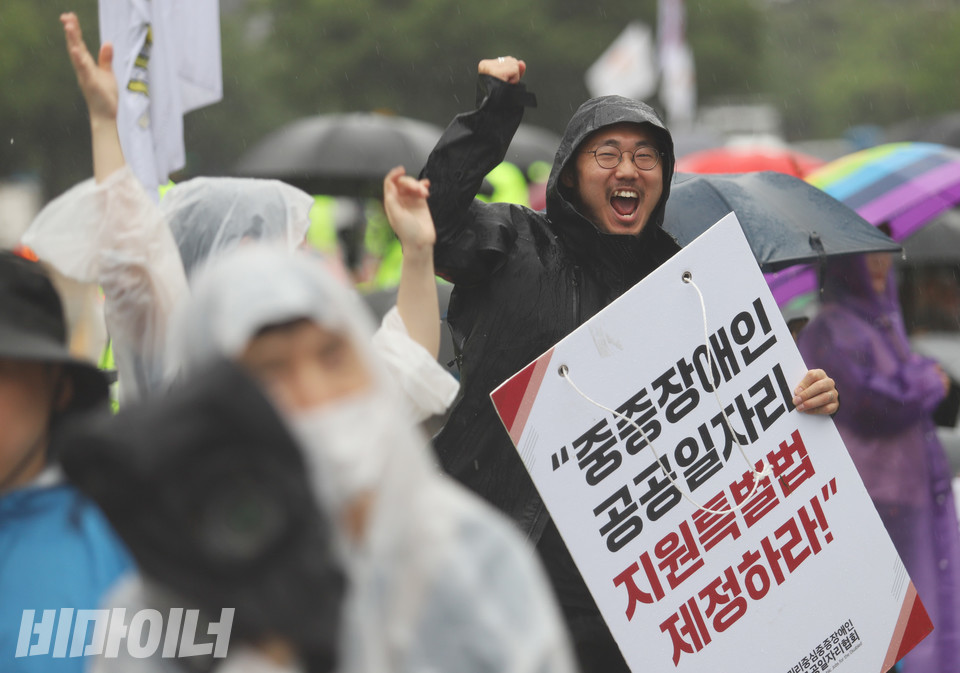 우정규 전국권리중심중증장애인맞춤형공공일자리협회 활동가가 “중증장애인 공공일자리 지원 특별법 제정하라”고 적힌 피켓을 들고 환호하고 있다.