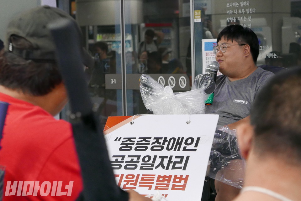 노지성 대구사람장애인자립생활센터 활동가가 발언하고 있다. 전날 폭우 속 전동행진을 하느라 그의 휠체어에는 비닐로 쌓여 있다. 사진 양유진