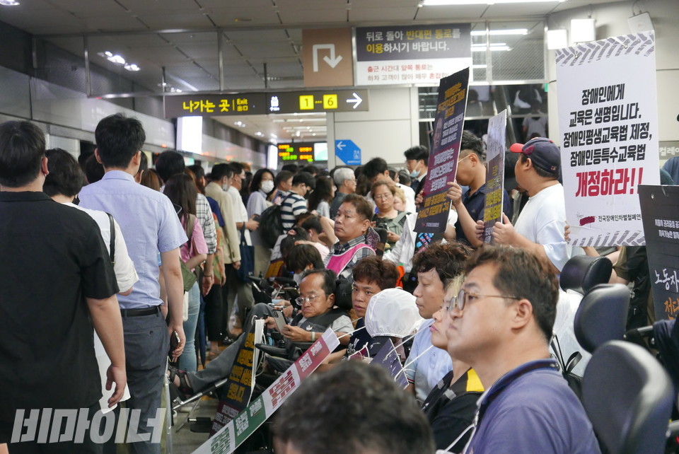 선전전을 진행 중인 활동가들. 그 앞을 휠체어를 이용하지 않는 시민들이 줄지어 지나가고 있다. 사진 양유진