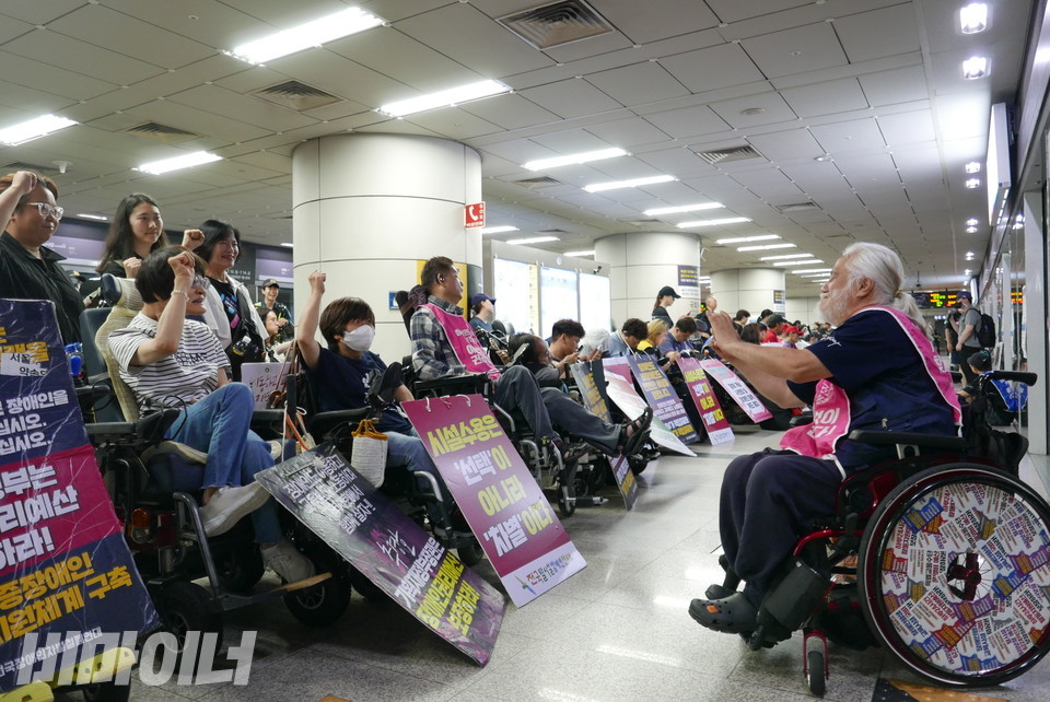 박경석 전장연 상임공동대표가 자신의 휴대전화로 “투쟁”을 외치는 활동가들을 찍고 있다. 사진 양유진