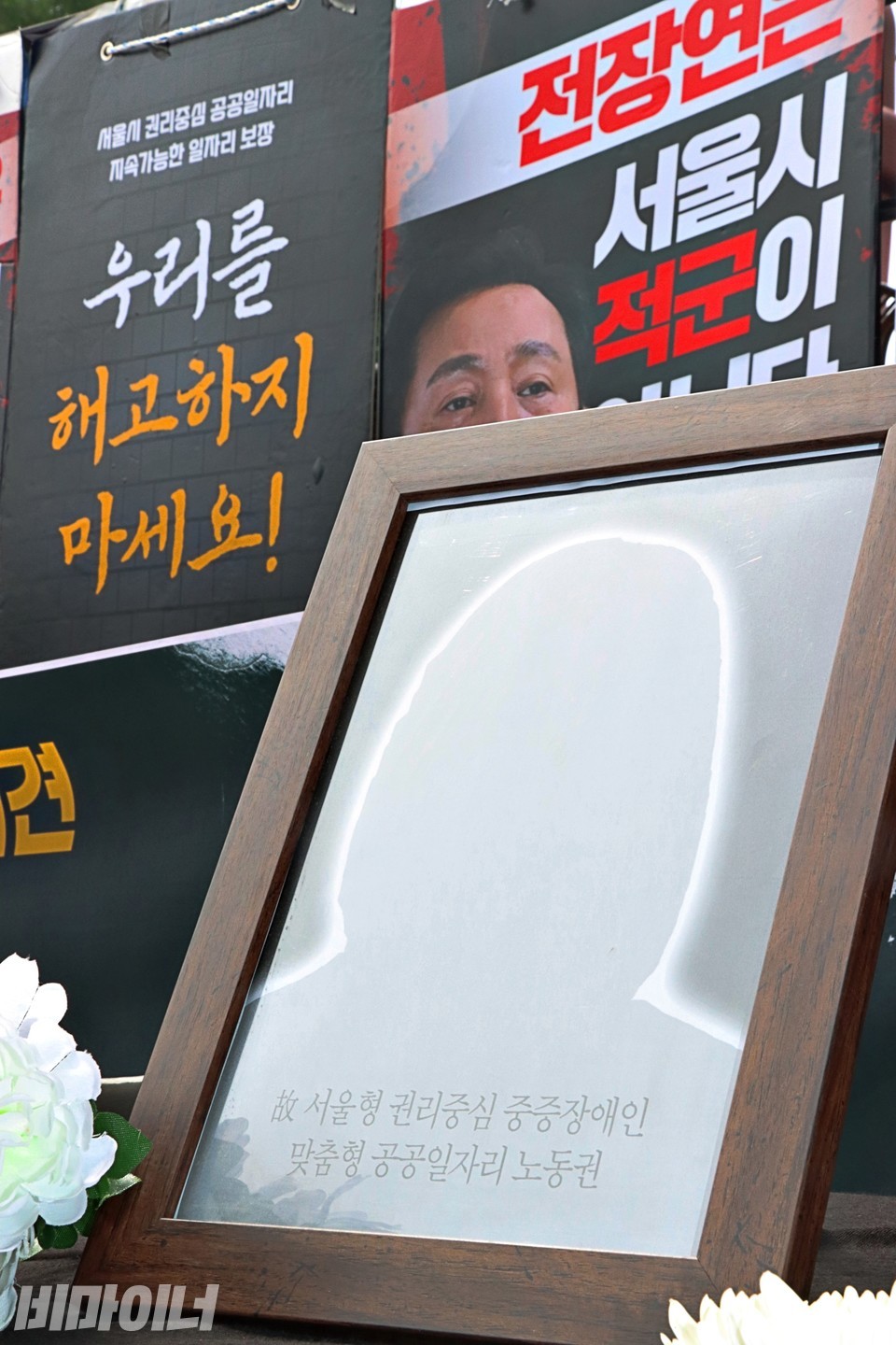 서울형 권리중심공공일자리의 영정 위로 오세훈 시장의 눈이 보인다. 사진 하민지