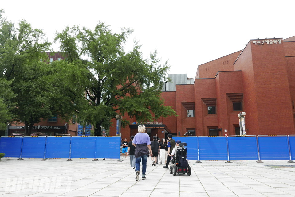 종로구청 직원과 경찰은 마로니에 공원에 파란색 울타리를 설치해 활동가들의 통행을 제한했다. 활동가들이 울타리 사이에 마련된 좁은 틈으로 통행 중이다. 사진 양유진