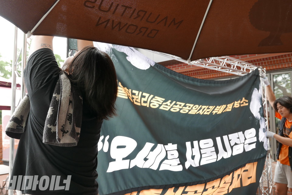 탁영희 노들장애인야학 교사가 트러스에 현수막을 걸고 있다. 사진 양유진