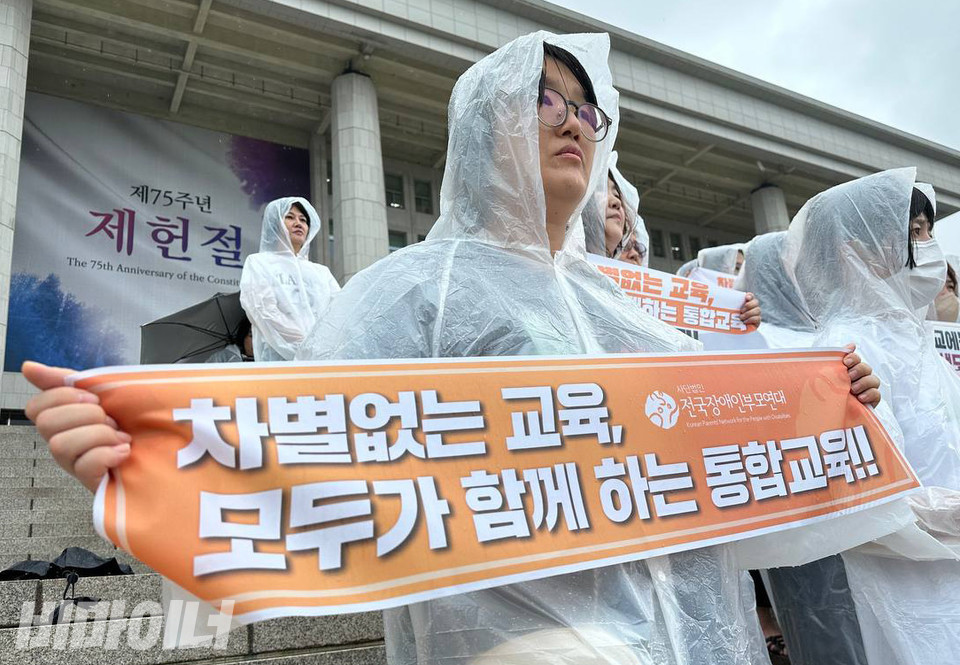 장애부모 활동가가 “차별 없는 교육, 모두가 함께하는 통합교육”이라고 적힌 현수막을 들고 있다. 사진 강혜민