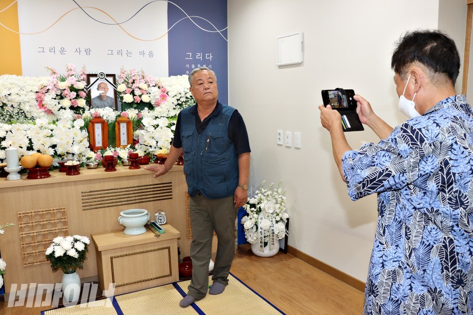 백광헌 동자동공공주택사업추진주민모임 부위원장이 영정이 된 김정호 협동회 이사장과 사진 촬영을 하고 있다. 사진 하민지