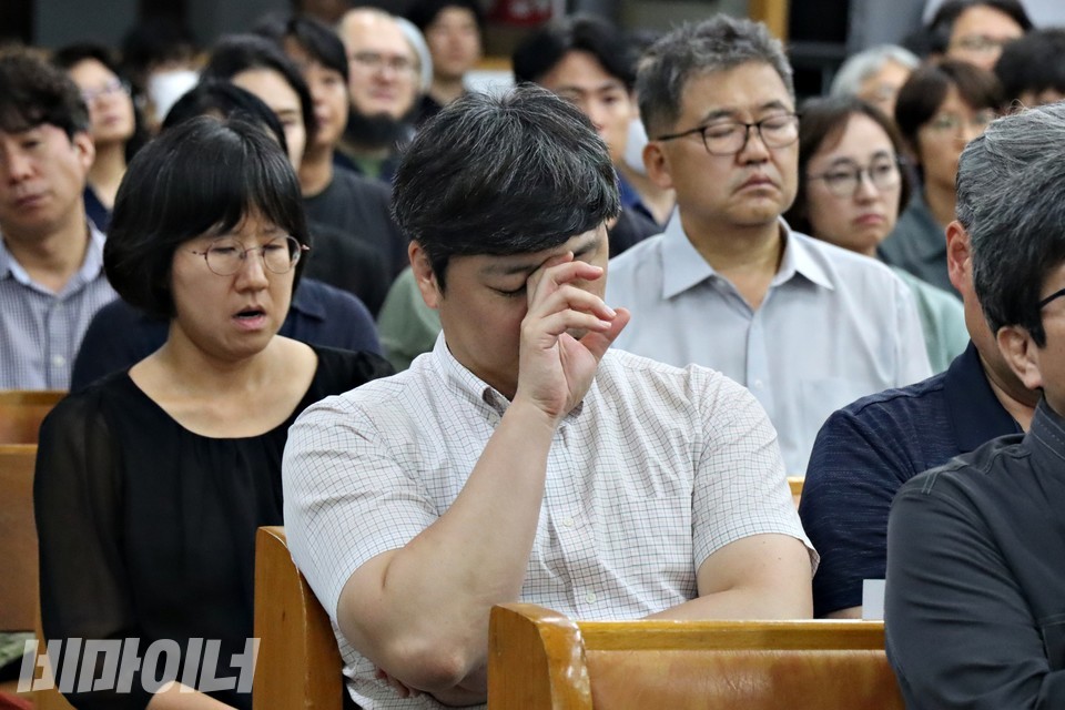 추모식에 참석한 사람이 슬픔에 잠겨 있다. 사진 하민지